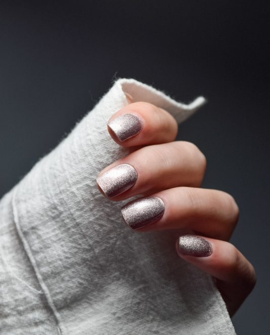 Hand mit UV Gel Wraps Rose Gold Glam – funkelndes Roségold mit Glitzer-Effekt.