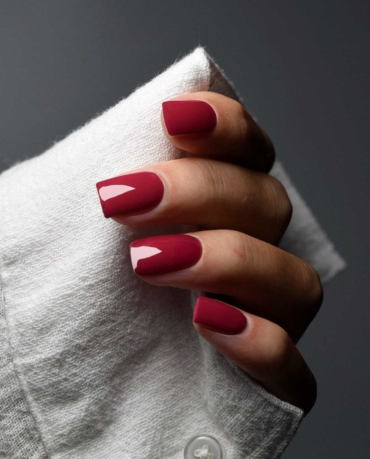 Hand mit Herbst Kuss UV Gel Wraps in kräftigem Weinrot