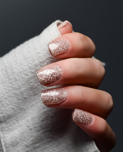 Hand mit UV Gel Wraps Prosecco Funkeln – Champagner-Glitzer Nägel im glänzenden Finish.