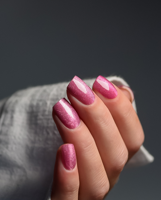 Hand mit UV Gel Wraps Himbeerhauch – Pink mit Cat Eye Effekt
