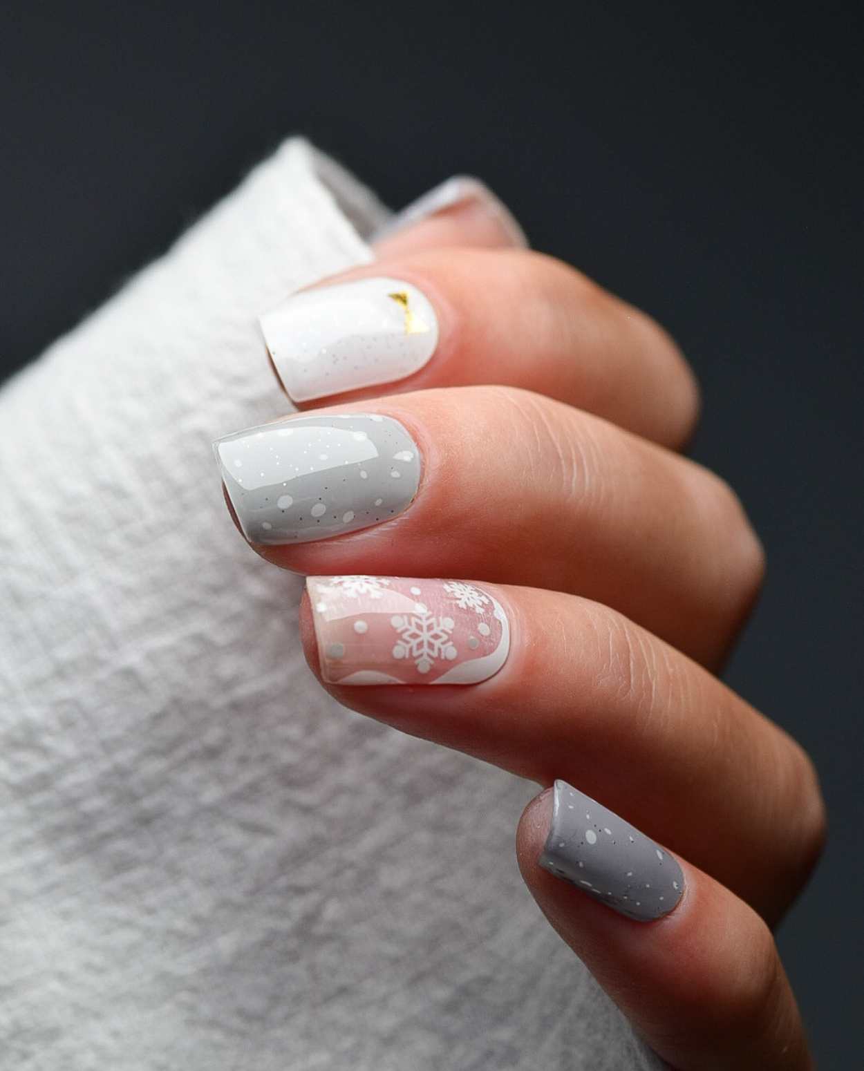 Schneegrau UV Gel Wraps – graues und weißes Winterdesign mit Schneeflocken, Sprenkel-Optik und feinen Goldschleifen.
