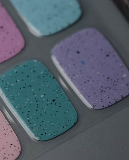 Candy Eggshell UV Gel Wraps in Pastellfarben mit schwarzem Eggshell-Sprenkleffekt auf einzelnen Nägeln