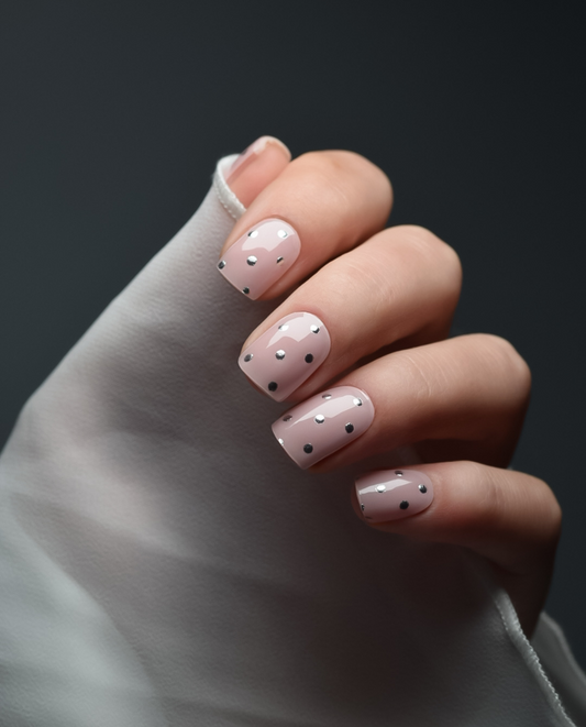 Crystal Dots – UV Gel Wraps in Nude mit schwarzen Punkten, getragen auf Nägeln.