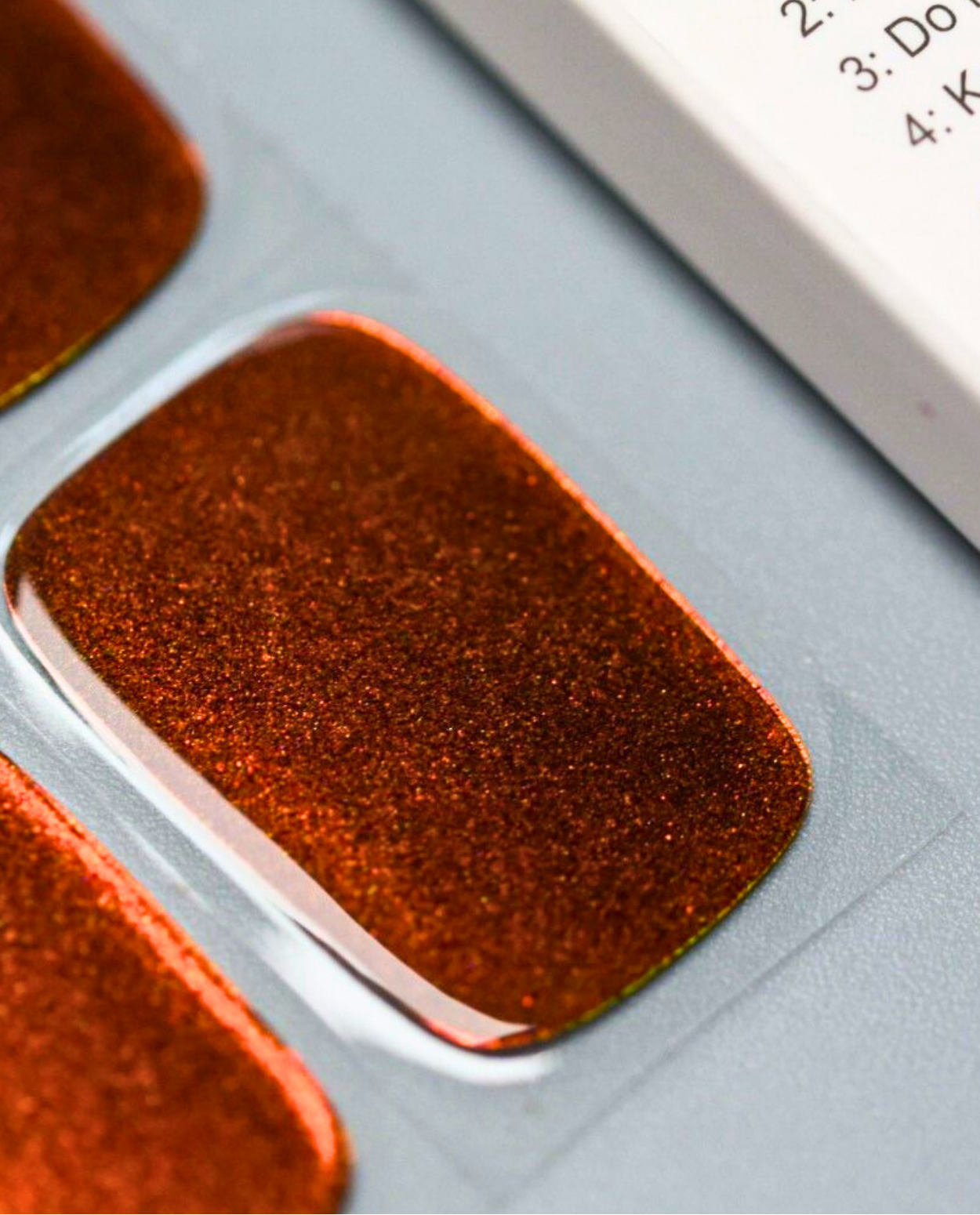 UV Gel Wraps Copper Flame – Nahaufnahme der changierenden Nail Wraps.