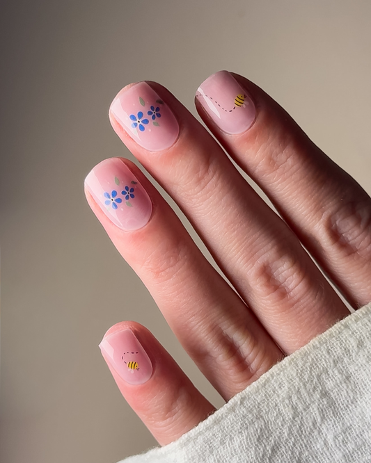 Whispered Blue UV Gel Wraps mit milky Base und feinen blauen Blüten auf den Nägeln