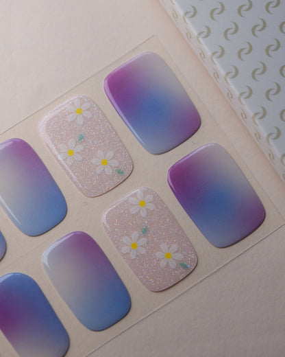 Abendblüte UV Gel Wraps auf dem Designbogen mit Farbverläufen in Flieder, Blau und Rosé sowie glitzernden Blütenakzenten.