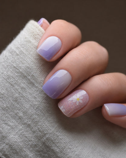 Abendblüte UV Gel Wraps in zartem Flieder mit glitzernden Blütenakzenten und sanften Farbverläufen auf den Fingernägeln.