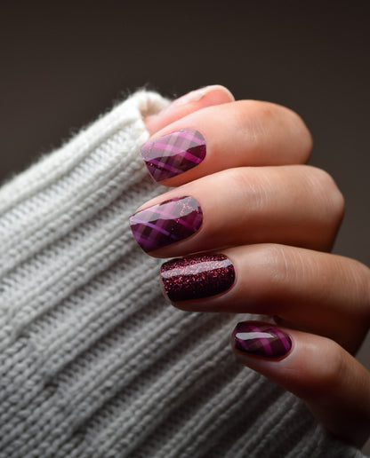 Hand mit aufgeklebten Nailpolish Wraps Berry Tartan – herbstliches Karomuster in Rot-Lila und Schwarz