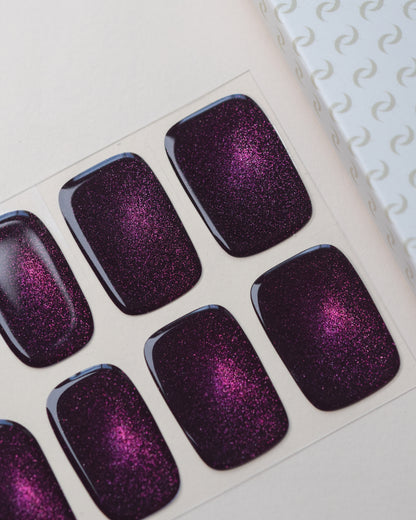 Black Cherry Cat Eye UV Gel Wraps auf dem Designbogen mit schimmerndem Cat-Eye-Effekt in dunklem Kirschrot und Violett.