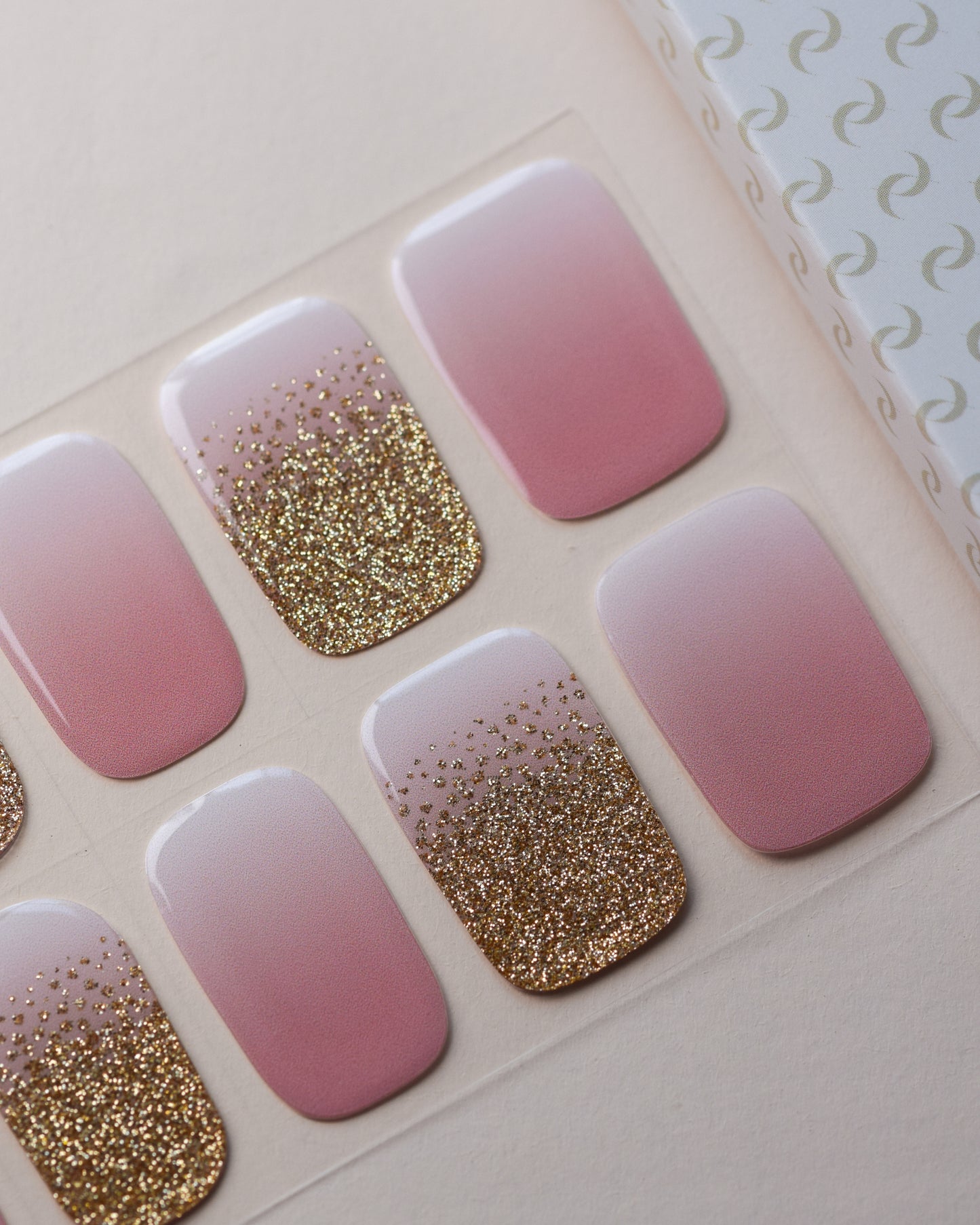 Blütenfunkeln UV Gel Wraps auf dem Designbogen mit Rosé-, Nude- und Glitzerdesigns.
