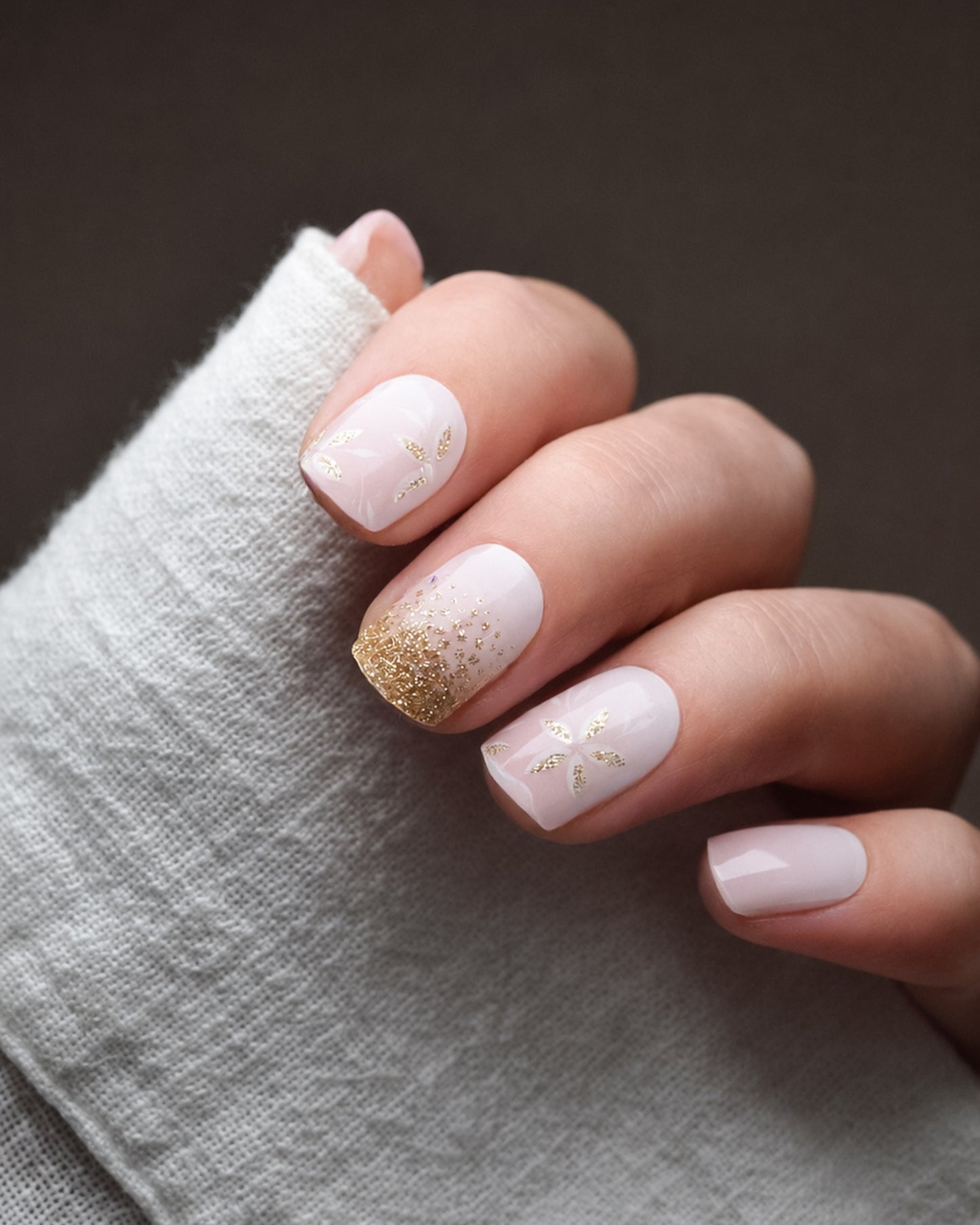 Blütenfunkeln UV Gel Wraps in zarten Rosé- und Nude-Tönen mit funkelnden Glitzerakzenten auf den Fingernägeln.