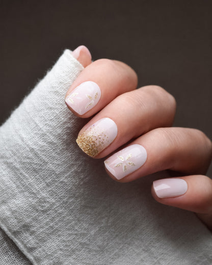 Blütenfunkeln UV Gel Wraps in zarten Rosé- und Nude-Tönen mit funkelnden Glitzerakzenten auf den Fingernägeln.