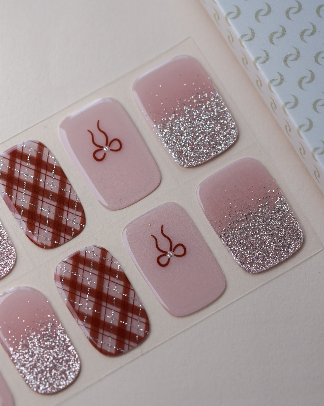 Bowtiful UV Gel Wraps auf dem Designbogen mit Schleifen, Vichy-Karo und romantischen Rosétönen.