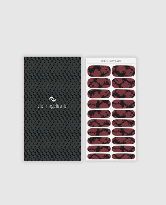 Bogen mit Nailpolish Wraps Burgundy Lace – 20 Wraps mit schwarzer Basis und burgunderrotem Spitzenmuster.