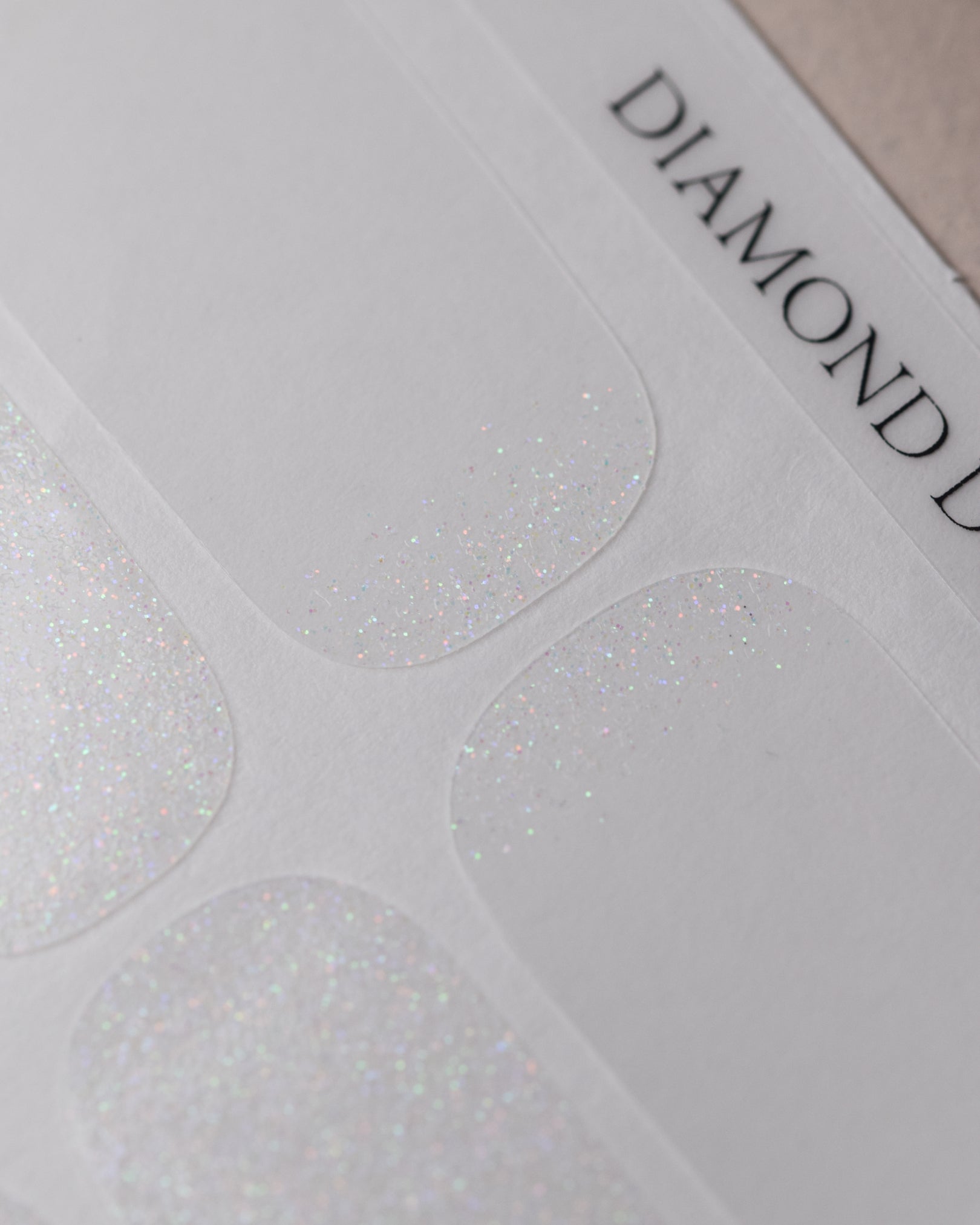 Diamond Dust Nailpolish Wraps als kompletter Folienbogen mit 20 selbstklebenden Nagelfolien in verschiedenen Größen.