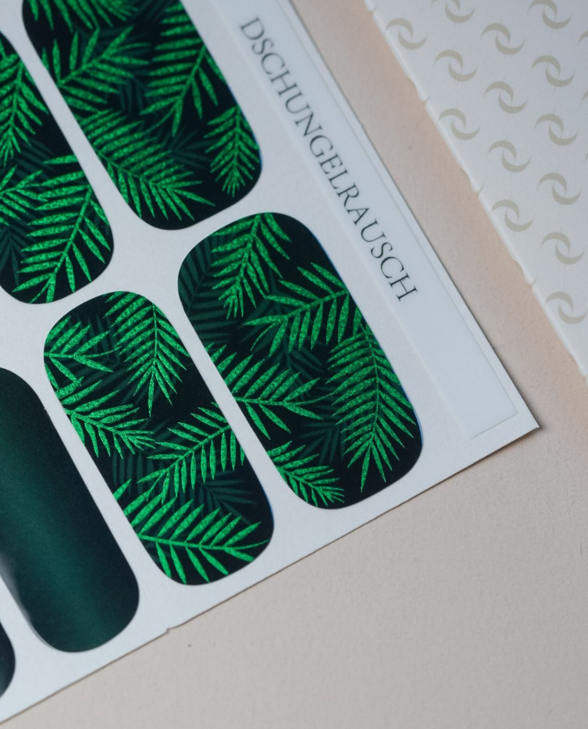 Dschungelrausch Nailpolish Wraps – Produktfoto mit grünem Blatt-Design auf dunklem Hintergrund