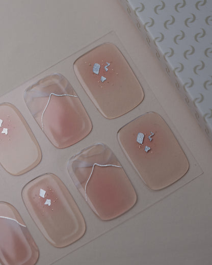 Dusty Glam UV Gel Wraps auf dem Designbogen mit rosafarbenen Nude-Tönen, Schimmer und Glitzerdetails.