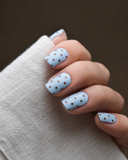 Forget Me Dot UV Gel Wraps in zartem Himmelblau mit schwarzem Polka-Dot-Muster auf den Fingernägeln.