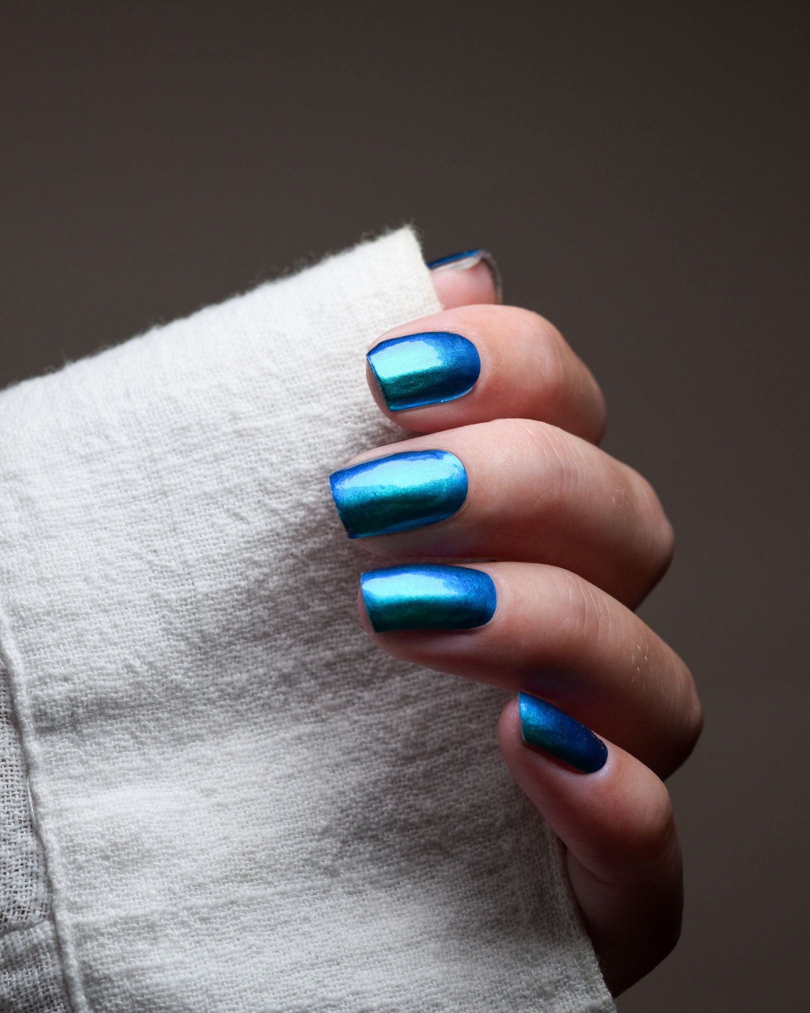 Ilvy Blue Nailpolish Wraps auf den Fingern getragen – Chrome-Design mit faszinierendem Farbwechsel zwischen Türkis, Petrol und Blaugrün.