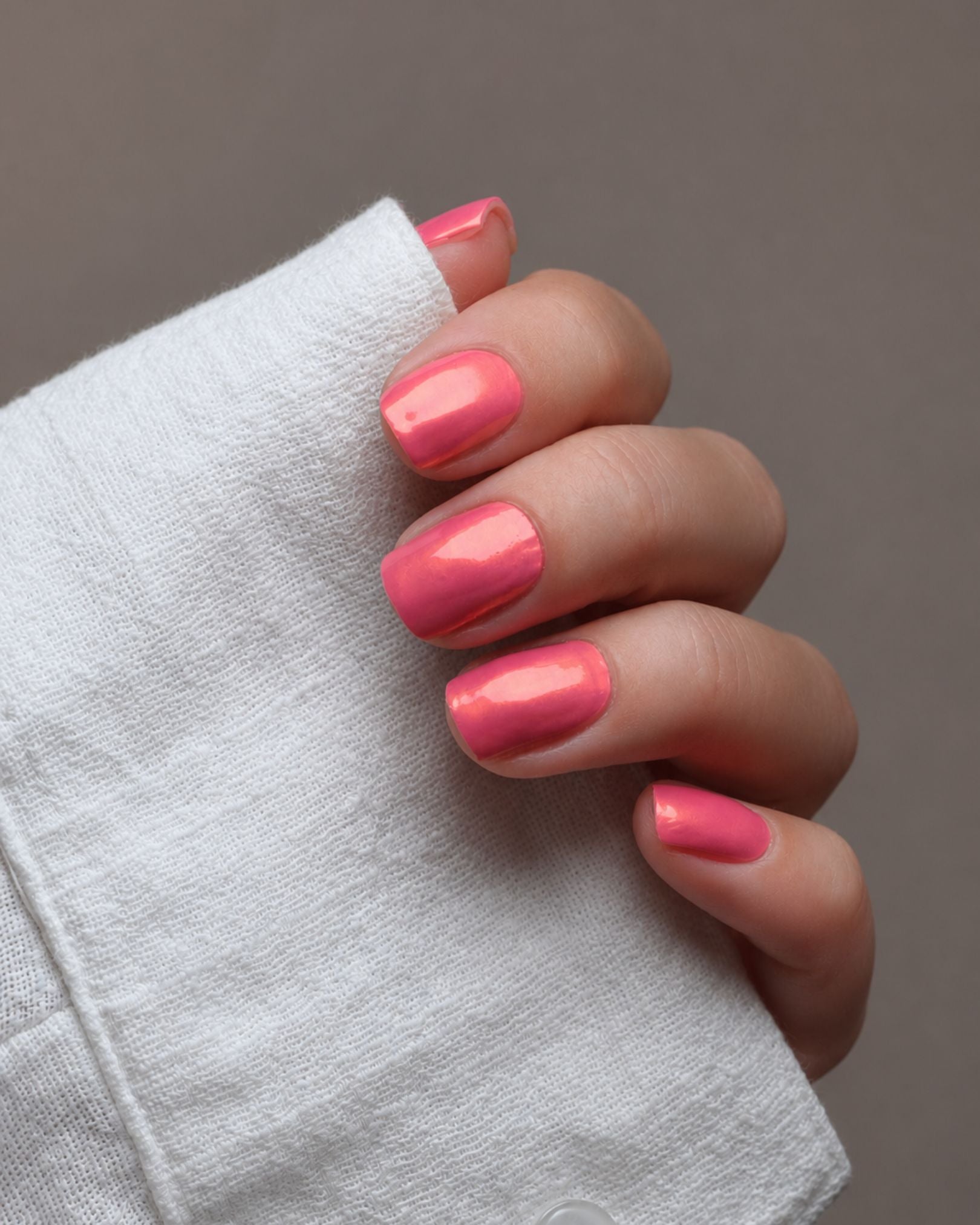 Ilvy Nailpolish Wraps auf den Fingern getragen – Chrome-Design mit faszinierendem Farbwechsel in leuchtenden Pink- und Koralltönen.