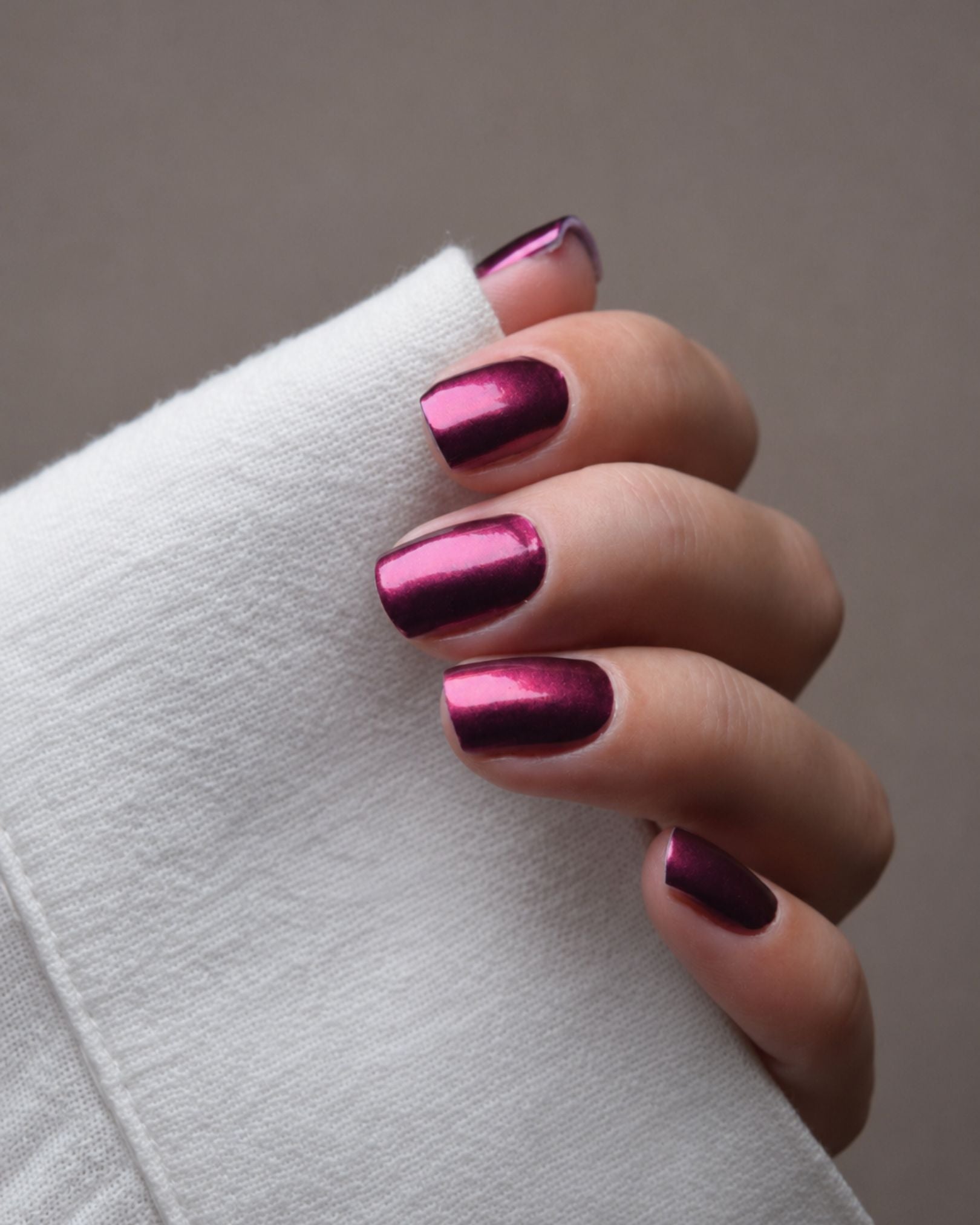 Ilvy Pink Nailpolish Wraps auf den Fingern getragen – Chrome-Design mit faszinierendem Farbwechsel zwischen Beerenton, Pink und Violett.