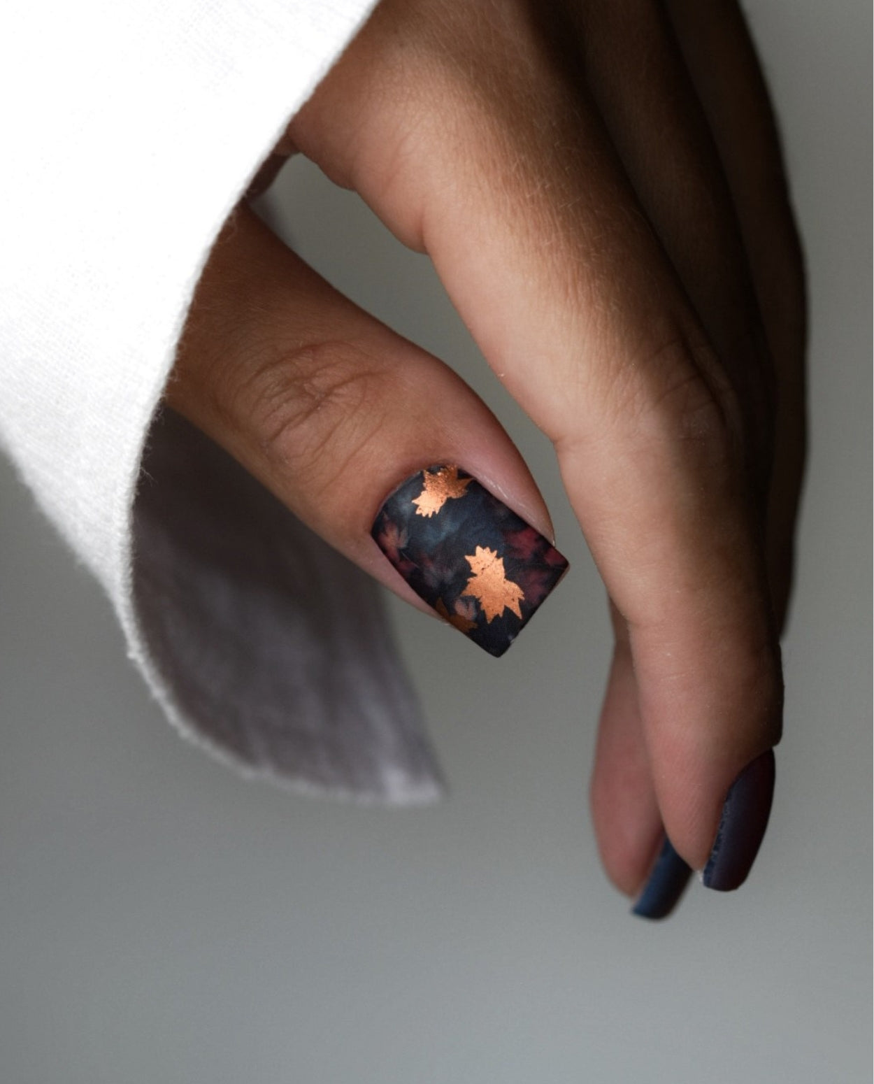 Maniküre mit Nailpolish Wraps in sattem Herbstdesign – perfekt aufgeklebte Folien mit gleichmäßigem Glanz.