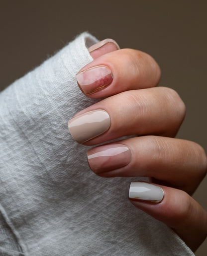 Hand mit Nailpolish Wraps Rosé Marble Veins – zarter Roséton kombiniert mit weißen und dunklen Marmor-Effekten.
