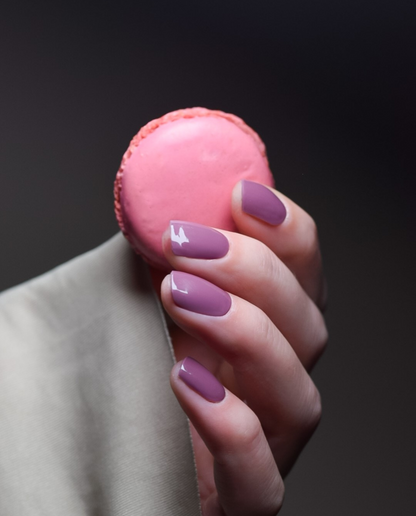 Plum Gloss – UV Gel Wraps in Pflaumenlila, getragen mit Macaron als Deko.