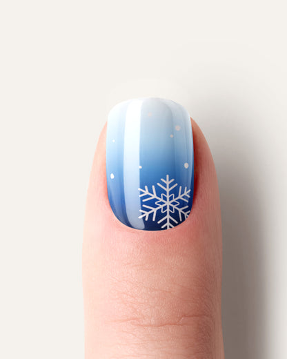 Flockentanz UV Gel Wraps – blaues Winterdesign mit weißen Schneeflocken und sanftem Glanz.