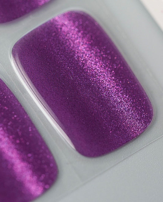 Traubenschimmer UV Gel Wraps – Nahaufnahme des lila Cat-Eye Designs mit intensivem Glitzer.