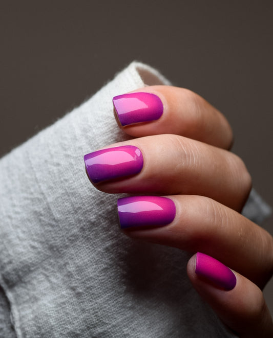 Hand mit UV Gel Wraps Velvet Night – Ombré-Nägel in Pink und Violett.