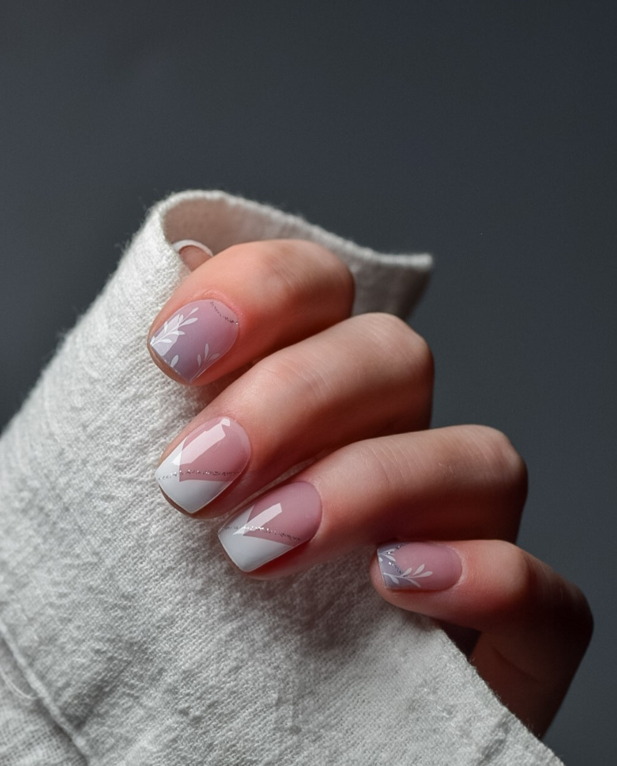 Minimalist French UV Gel Wraps – eleganter French Look mit Nude-Basis, weißen Linien und feinen Blättermotiven.
