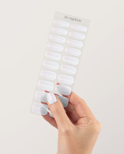 UV Gel Wraps Babyboomer Glimmer – Ombré Nailwraps mit Glanz und Glitzer veredelt - Hand hält Träger der Nail Wraps