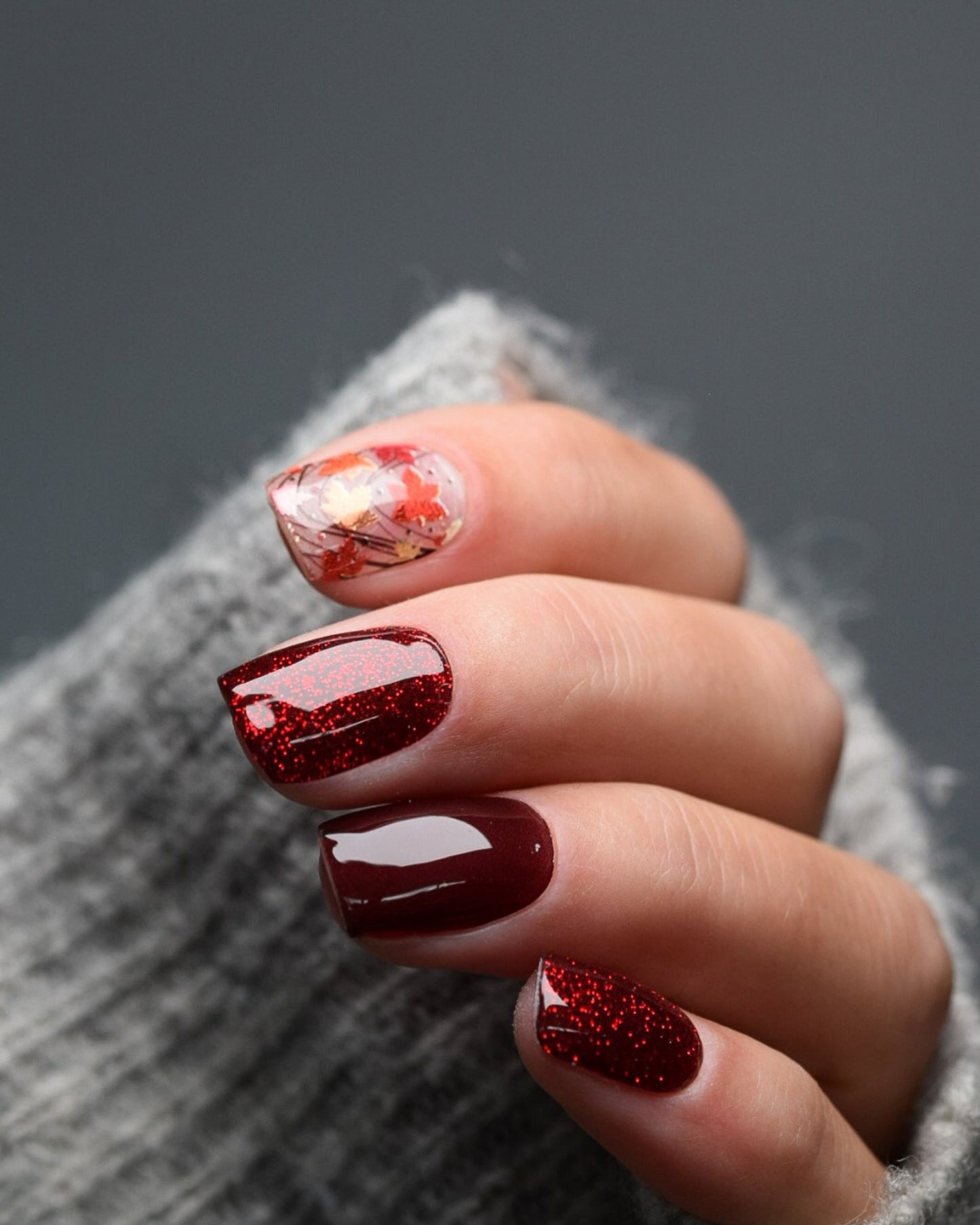 Detailaufnahme – UV Gel Wraps mit Ahornblättern in Rot, Orange und Gold für ein warmes, elegantes Herbstdesign.

