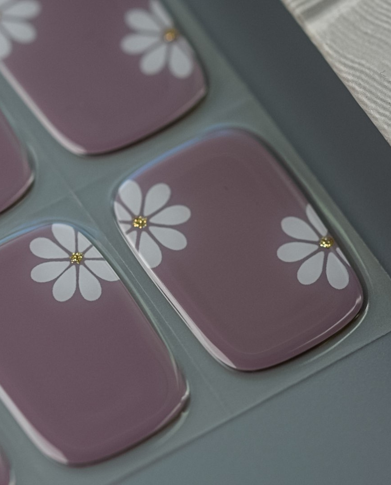 UV Gel Wraps Wolkengarten – zarte Blüten auf fliederfarbenem Grund.