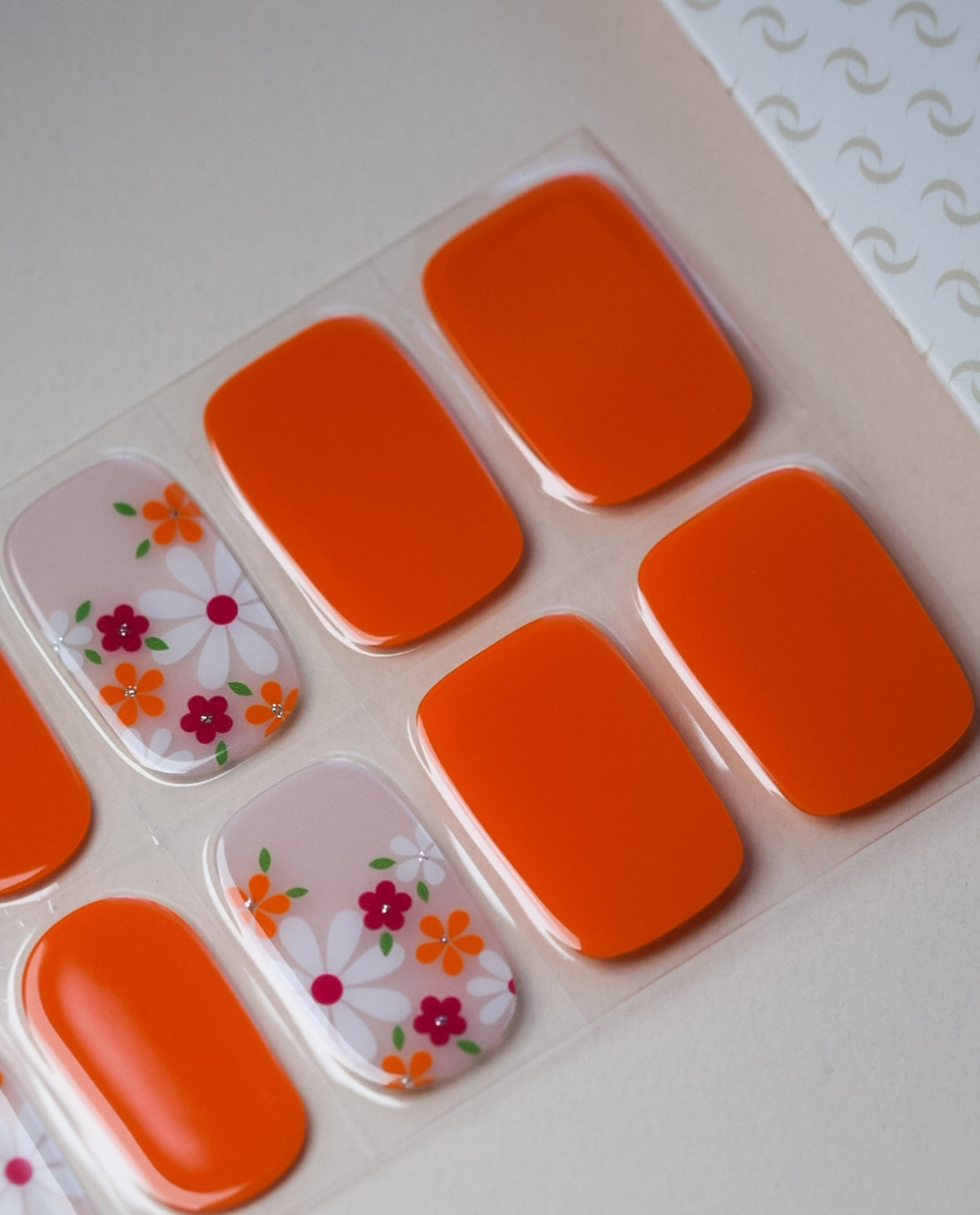 Produktbogen UV Gel Wraps Orange Blossom – 20 Streifen Semi-Cured in Orange mit Blumenmustern.