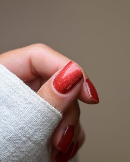 Mulled Wine – rote UV Gel Wraps mit feinem Schimmer-Effekt, perfekt für bis zu 3 Wochen Haltbarkeit, Nail Wraps  auf Daumen aufgeklebt.
