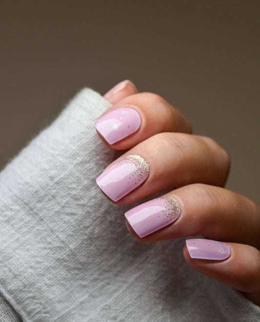 Hand mit UV Gel Wraps Twinkle Rose – zarte Rosé-Nägel mit goldenem Glitter.