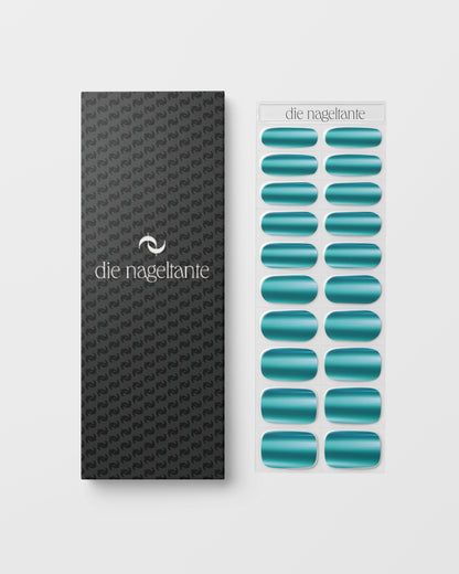 Anwendung der Deep Dive UV Gel Wraps – metallisch glänzende Nagelfolien werden auf den Nagel geklebt und unter UV-Licht ausgehärtet.