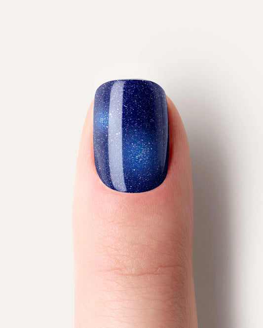 Midnight Tale UV Gel Wraps – tiefblauer Cat Eye Effekt mit galaktischem Glitzerschimmer auf den Nägeln.
