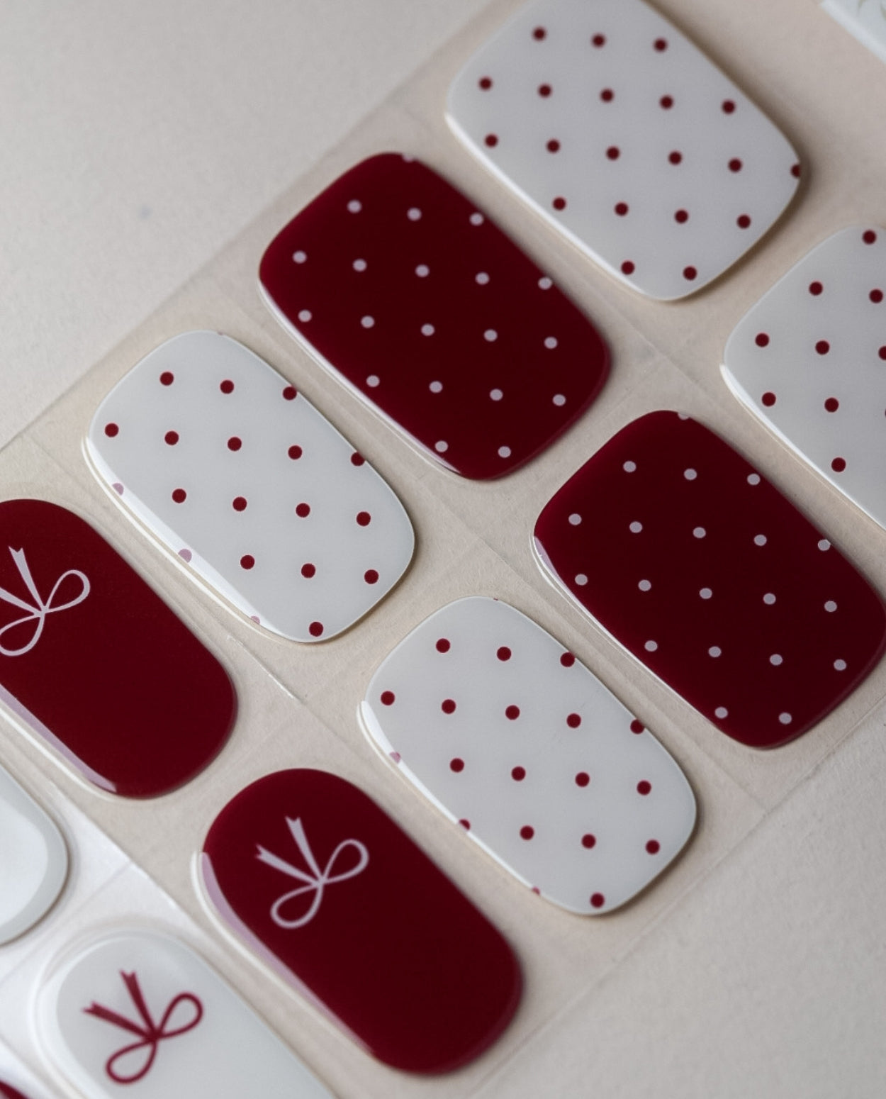 Snowberry Bow UV Gel Wraps – Nageldesign in Weiß und Beerenton mit feinen Schleifen und Pünktchen.