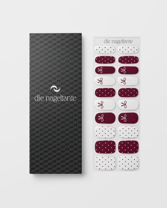 Snowberry Bow UV Gel Wraps – Nageldesign in Weiß und Beerenton mit feinen Schleifen und Pünktchen.
