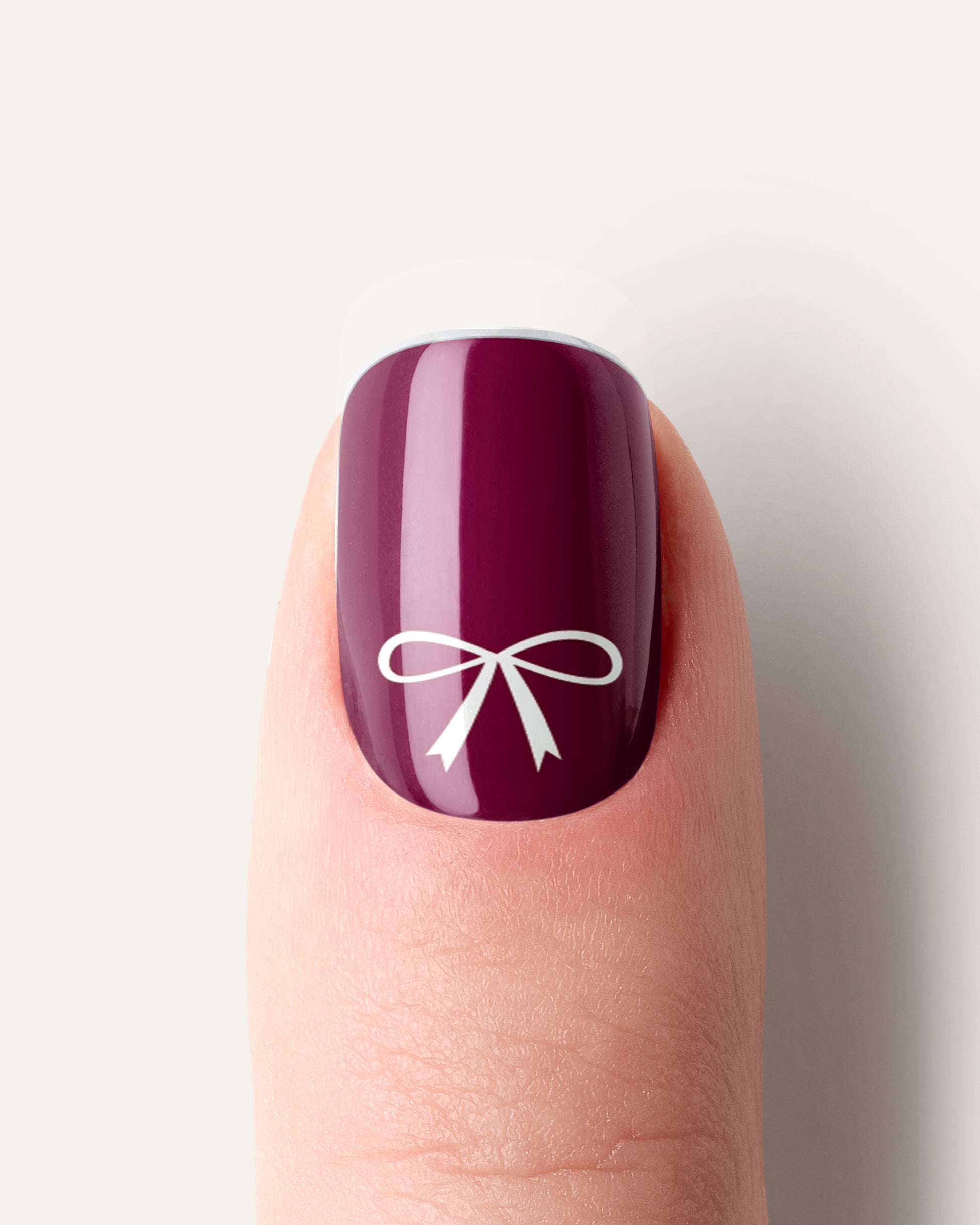 Nahaufnahme der Snowberry Bow UV Gel Wraps – elegantes Winterdesign mit zarten Schleifen und schneeweißen Punkten.
