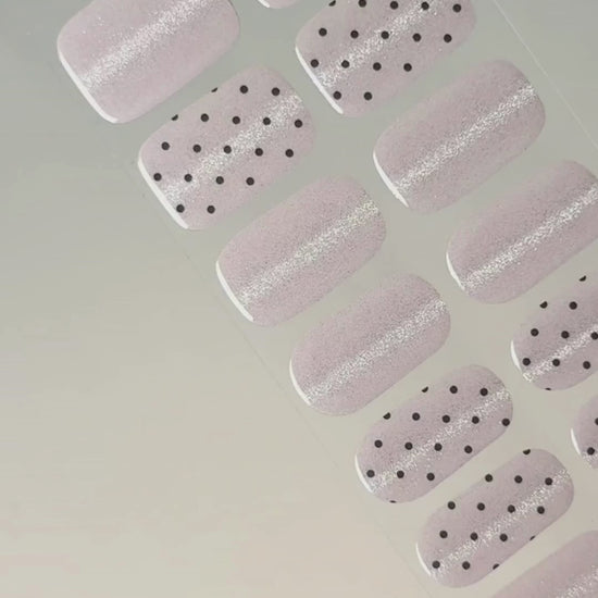 Anwendung und Detailansicht der Pink Prosecco Cat Eye UV Gel Wraps mit roséfarbenem Schimmer und schwarzen Akzenten.