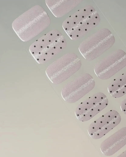 Anwendung und Detailansicht der Pink Prosecco Cat Eye UV Gel Wraps mit roséfarbenem Schimmer und schwarzen Akzenten.