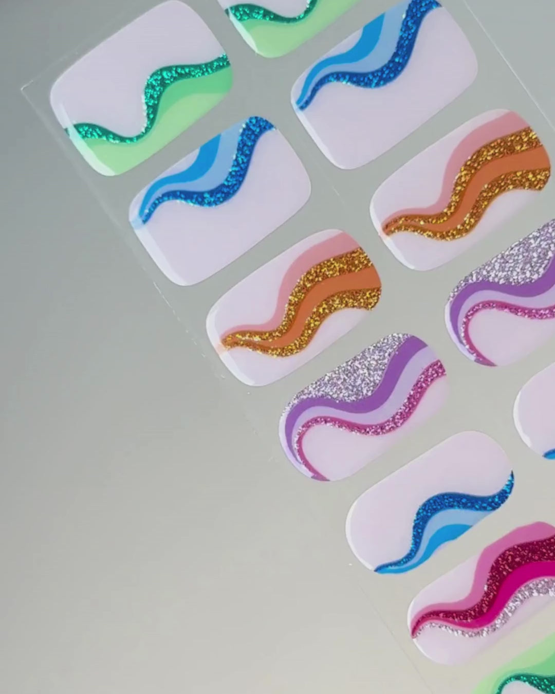 Anwendung und Detailansicht der Mood Swing UV Gel Wraps mit farbenfrohen Wellenmustern und lebendigen Sommerfarben.
