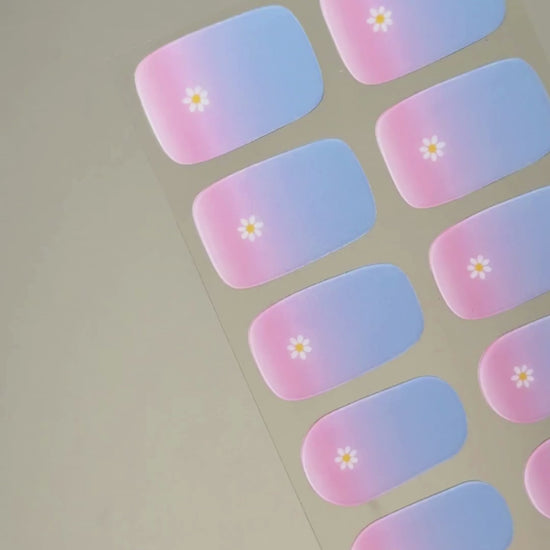 Video zur Anwendung und Ergebnis der Bubblegum Blooms UV Gel Wraps mit Pastellverlauf und Blüten-Design. Schritt für Schritt Aufkleben und Aushärten für eine langanhaltende Maniküre mit uv nailwraps von Die Nageltante.