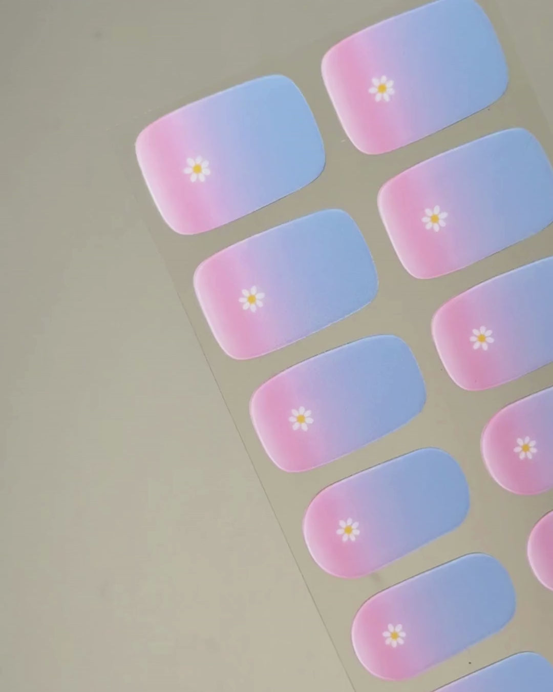 Video zur Anwendung und Ergebnis der Bubblegum Blooms UV Gel Wraps mit Pastellverlauf und Blüten-Design. Schritt für Schritt Aufkleben und Aushärten für eine langanhaltende Maniküre mit uv nailwraps von Die Nageltante.