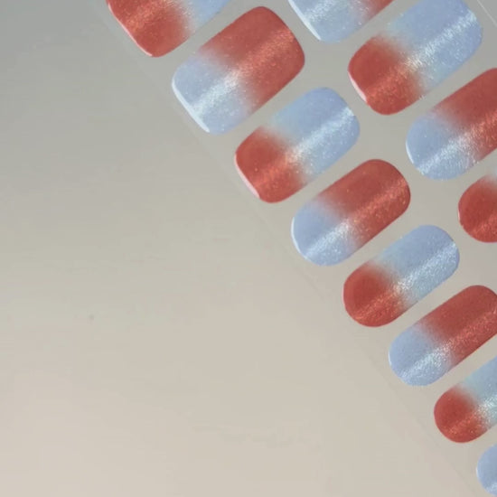 Anwendung und Detailansicht der Summer Fizz Cat Eye UV Gel Wraps mit korallrotem Farbverlauf, blauen Akzenten und magnetischem Schimmer.