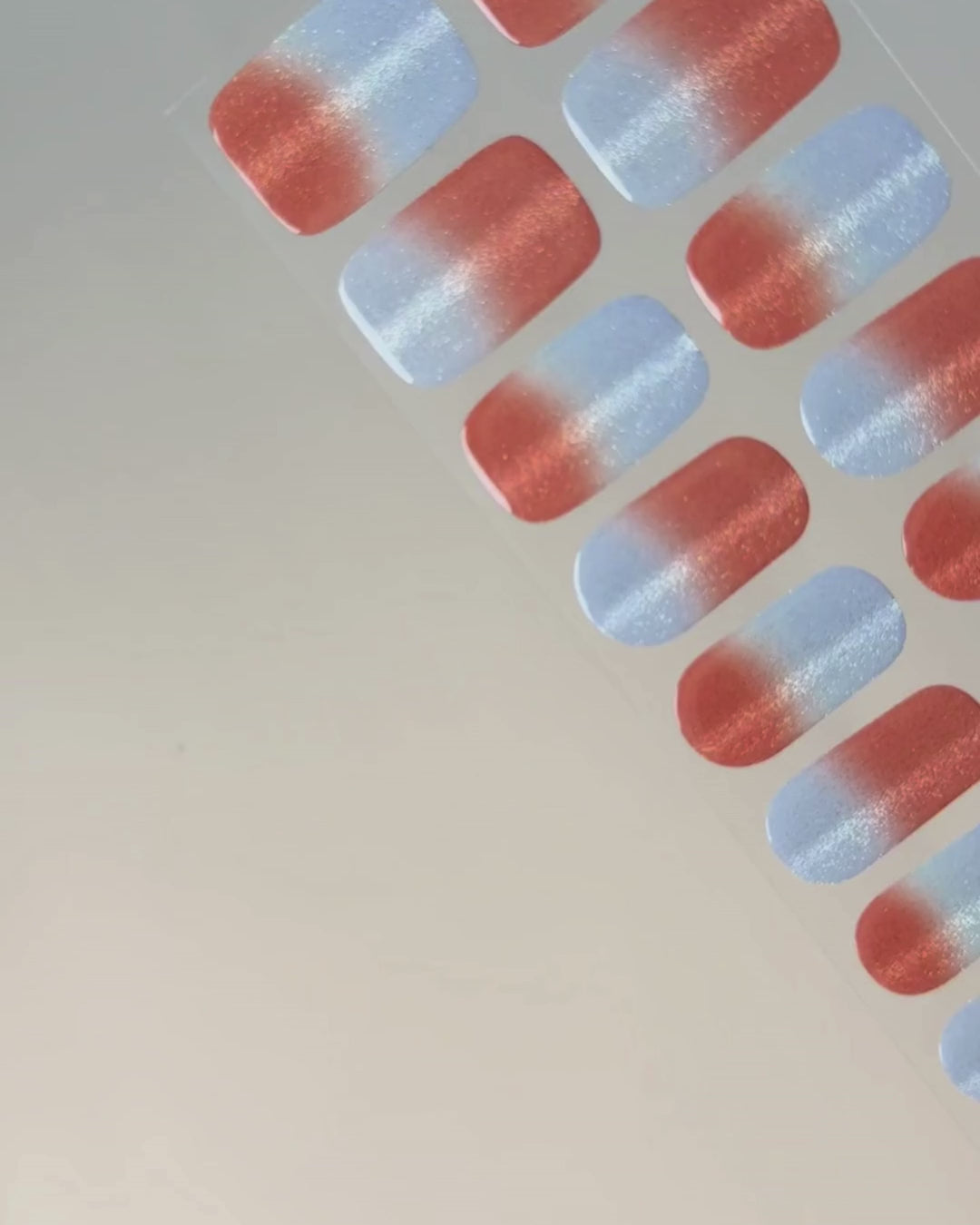 Anwendung und Detailansicht der Summer Fizz Cat Eye UV Gel Wraps mit korallrotem Farbverlauf, blauen Akzenten und magnetischem Schimmer.